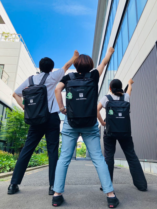 右手を掲げる3人の後ろ姿
